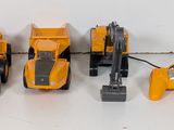 four toy construction vehicles that are lined up on the floor