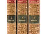 three old books sitting on top of each other on a white surface