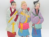 trois figurines représentant trois personnes vêtues de costumes traditionnels chinois