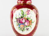 un vase rouge orné de fleurs peintes sur fond blanc