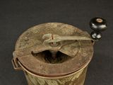 an old metal container with a wooden handle on a table