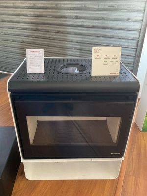 un micro-ondes noir et blanc posé sur un parquet