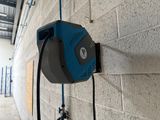 a blue and black electric charger attached to a brick wall