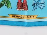 the blue scarf has a picture of a man in a hat and boots on it