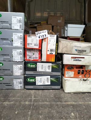 Plusieurs cartons contenant du matériel électronique sont empilés les uns sur les autres par terre.