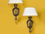 three lamps on a yellow wall with a white shade on them