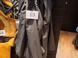 un manteau accroché au mur à côté d'une chaise