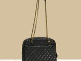 a black quilted handbag with a gold chain strap