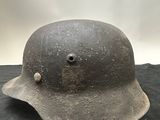 an old helmet is sitting on a black cloth on a table