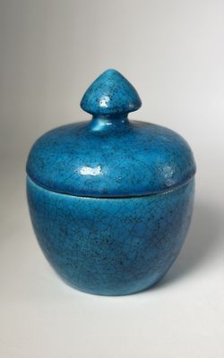 an image of a blue vase with a lid on a white surface