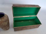 a small wooden box with a green lid next to a vase
