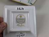 someone is holding a white plate with a gold and white design