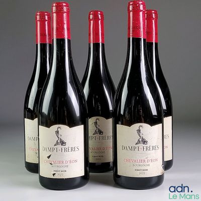 trois bouteilles de vin rouge posées sur une table l'une à côté de l'autre