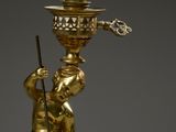 a gold statue of a boy holding a lamp