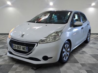 La petite voiture blanche est garée dans le garage, sur le sol à carreaux.