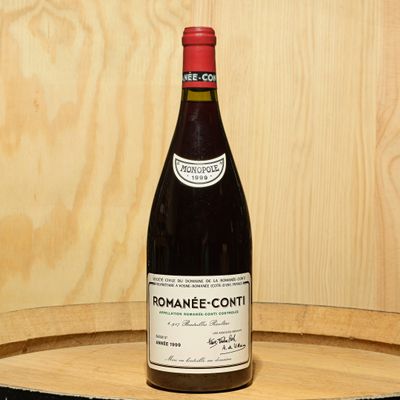 a bottle of wine sitting on top of a wooden barrel