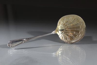 une cuillère posée sur une table, dans laquelle se trouve une autre cuillère
