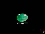 a close up of a green jade stone on a black surface