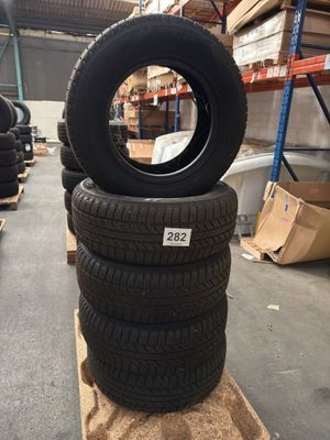 tires stacked on pallets in a warehouse with boxes and pallets