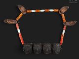 un gros plan sur un collier composé de perles en bois, avec des perles orange et blanches