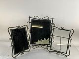three black and white picture frames sitting on top of a white table