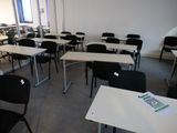 des tables et des chaises dans une pièce dotée de nombreuses fenêtres