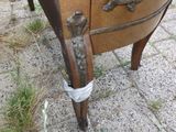 une commode en bois posée par terre, sur laquelle sont posés deux oiseaux