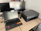 a laptop and printer sitting on a desk next to each other