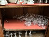 a wooden cabinet with wine glasses and cups on it