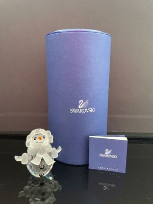 figurine en cristal représentant un éléphant blanc assis à côté d'une boîte bleue