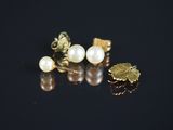 trois paires de boucles d'oreilles en perles et en or sur un fond noir