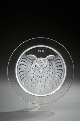 une plaque de verre sur laquelle est représenté un hibou, posée sur un socle