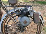 an old motorcycle that is parked in the grass