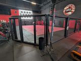 the inside of a gym with red and black walls and a cage