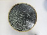 a black and white marble table top with a gold rim