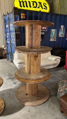 une série de bobines en bois disposées sur une table dans un entrepôt