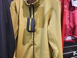 une veste jaune accrochée à un portant dans un magasin