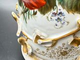 a vase with flowers painted on it sitting on a table