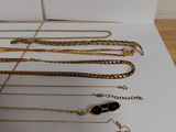 a lot of gold necklaces and bracelets sitting on a table