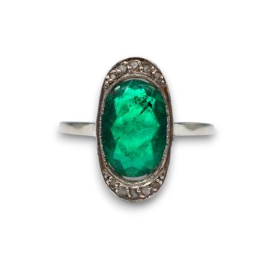 a close up of a ring with a green stone in it