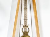 une horloge en bois posée sur un socle et munie d'un pendule