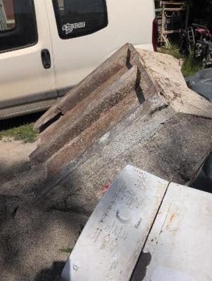 a white van parked next to a pile of junk