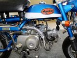 a blue motorcycle parked in a garage with a black seat