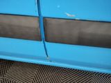 a close up of a blue car door with a hole in the side
