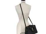 a black handbag sitting on top of a mannequin mannequin