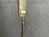 une cuillère en argent avec un manche en argent posée sur un linge gris