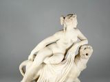 a white marble statue of a woman on a lion