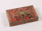 an old red and gold box with a floral design on it