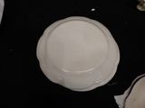 a white plate sitting on a black table with a knife and fork