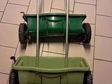 two lawn mowers sitting on the floor next to each other